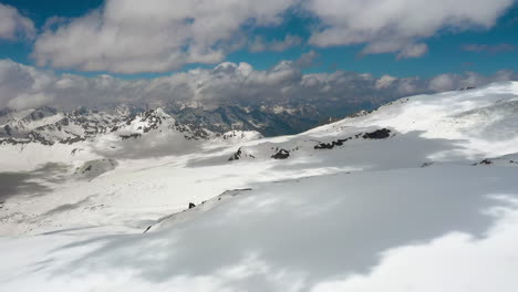 air flight through mountain clouds over beautiful snow-capped peaks of mountains and glaciers.