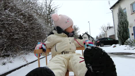 a little girl is on a snow sleigh