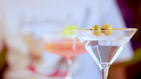 a variety of cocktails in elegant glassware with vibrant colors and garnishes, set against a blurred background
