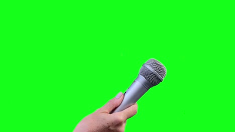 mano con micrófono haciendo una entrevista para los medios de comunicación aislados en pantalla verde, micrón cortado en fondo de croma verde. cerca. 4k.