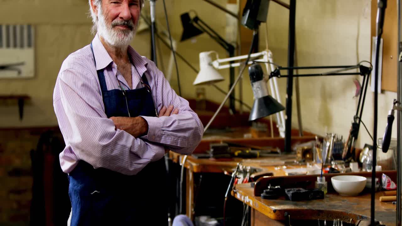 retrato de un orfebre confiado de pie con los brazos cruzados 4k