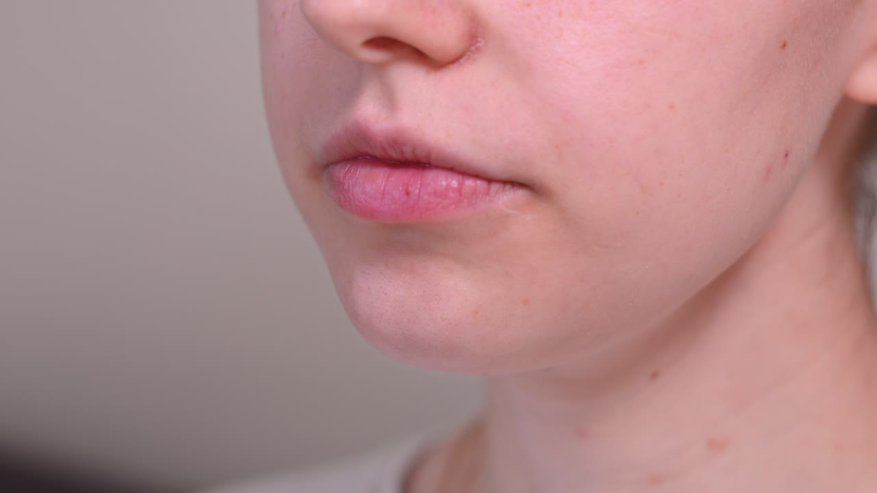 A Lady is Swallowing a Pill With a Glass of Water - Close Up