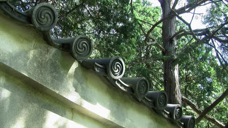 pared con azulejos decorativos en la parte superior de un jardín japonés