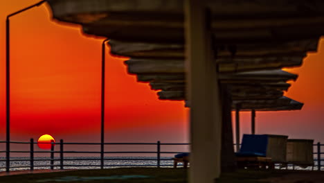 Timelapse-of-Ship-Anchoring-at-sunset-with-orange-sun-in-Hurghada,-Egypt