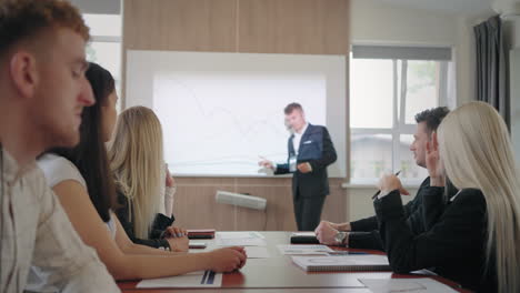 El-Entrenador-De-Negocios-Muestra-Un-Gráfico-Y-Habla-Frente-A-Especialistas-En-SEO-Y-Marketing.