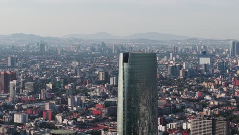 drone parallax view of mitikah tower, with cdmx in the rear