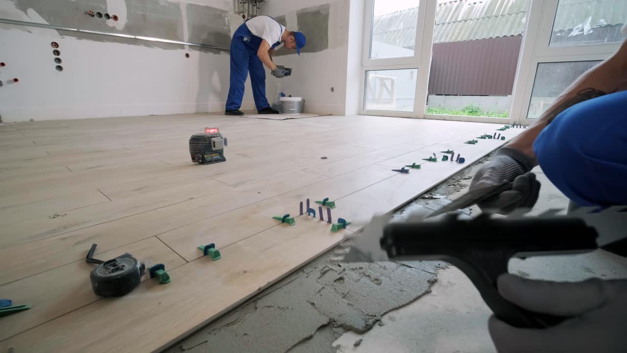 Installing ceramic floor tiles - measuring and cutting the pieces. Construction, renovation, repair apartment. Cuts tile. Tile cutting