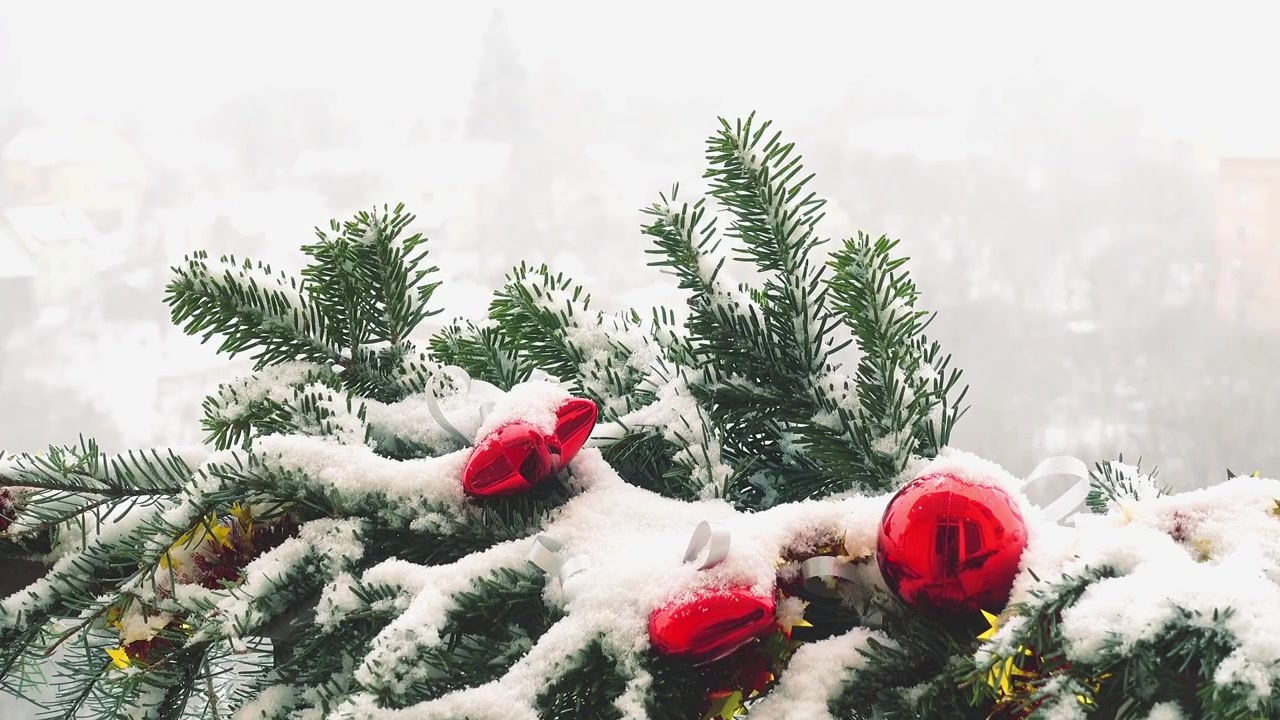 Kar altında oyuncaklarla süslenmiş Noel ağacı dalları