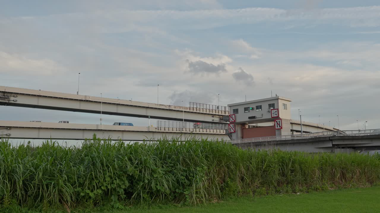 A view of the Sumida Sluice Gate with multiple layers of elevated highways and bridges in the background
