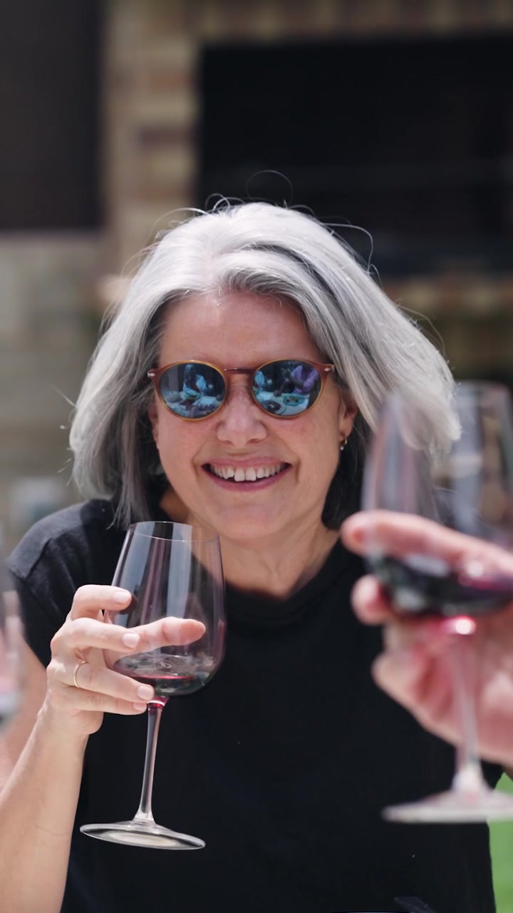 Mature Woman Laughing and Drinking Red Wine Outdoors