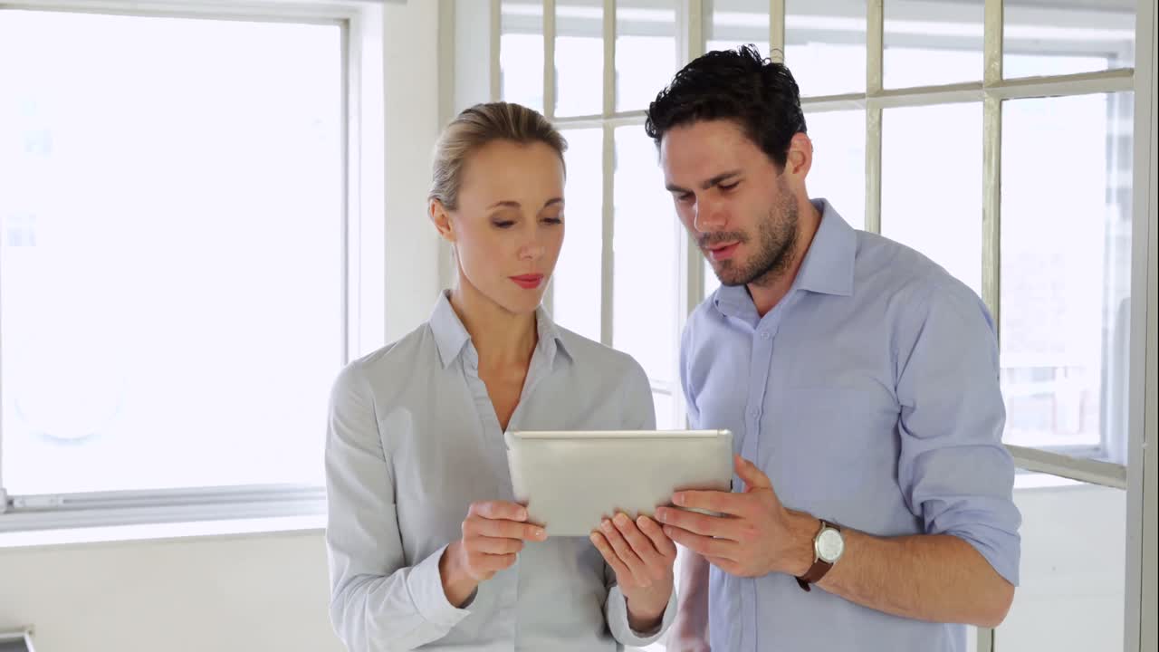 Colleghi soddisfatti che lavorano insieme con un tablet
