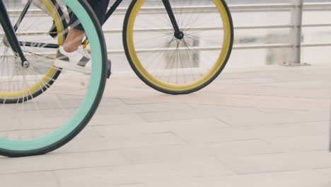 close up of two unrecognizable people riding bikes on the city bridge