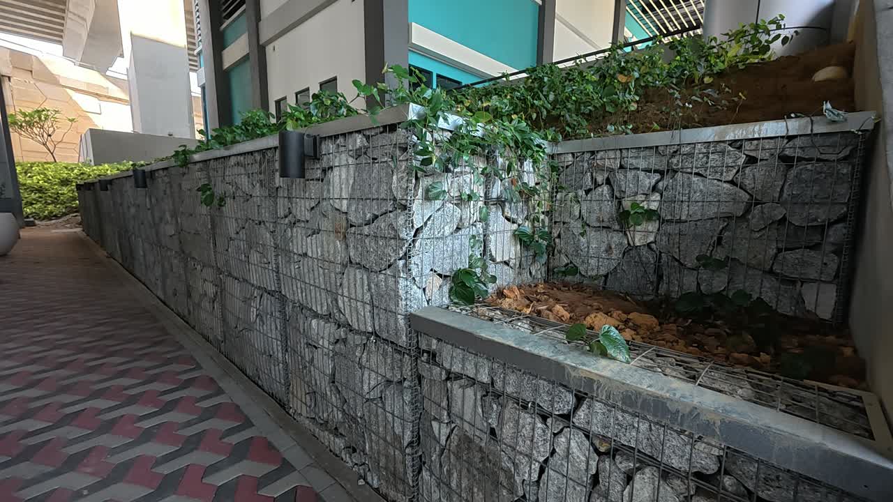 Un muro di sostegno in gabbioni offre supporto strutturale e controllo dell'erosione. Le gabbie metalliche sono riempite di rocce e rappresentano una soluzione di ingegneria civile duratura.