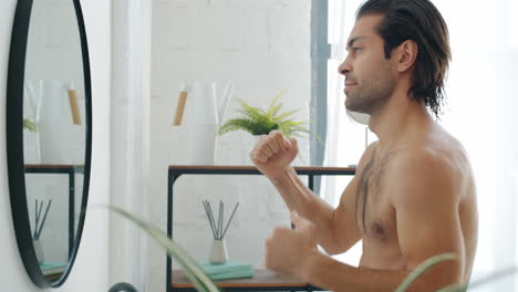 man checking hair in bathroom mirror