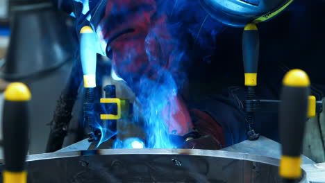 asia engineering technician worker working wearing industrial uniforms, welded iron mask at steel welding plants with sparks flying, industrial safety first concept.