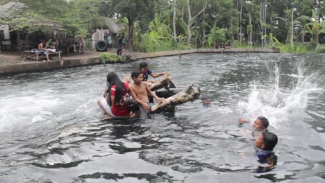 umbulan baths, pasuruan-indonesia. january 2020. young people are playing in a clear and fresh water source. holiday footage playing nature water