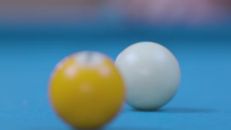 close up of hitting pool ball on blue billiards table - slow