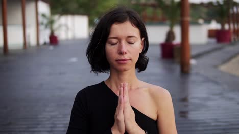 Frau-In-Schwarz-Sitzt-In-Lotus-Pose-Und-Meditiert-Und-Atmet-Allein-Im-Freien