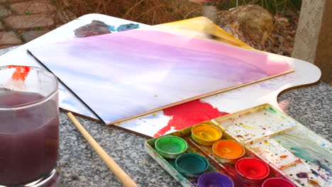 un artista pintando un colorido gradiente de arco iris con acuarela sobre un papel