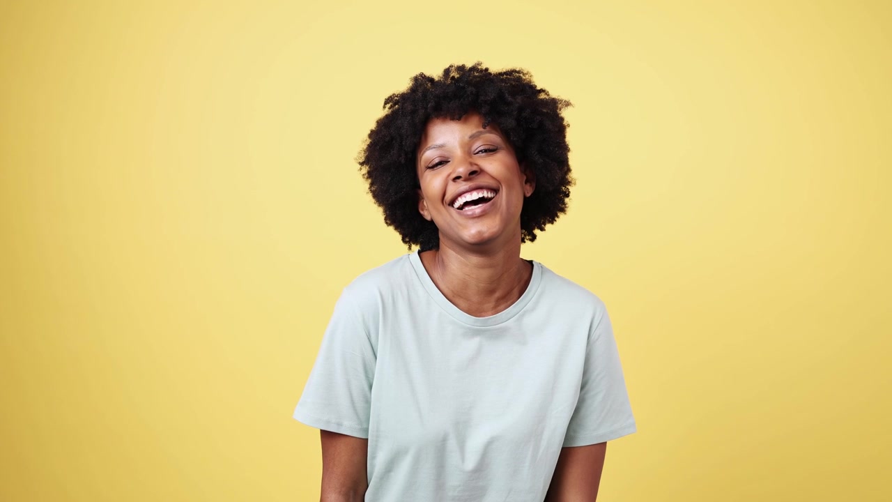 Cheerful African American Woman Blowing a Kiss and Laughing