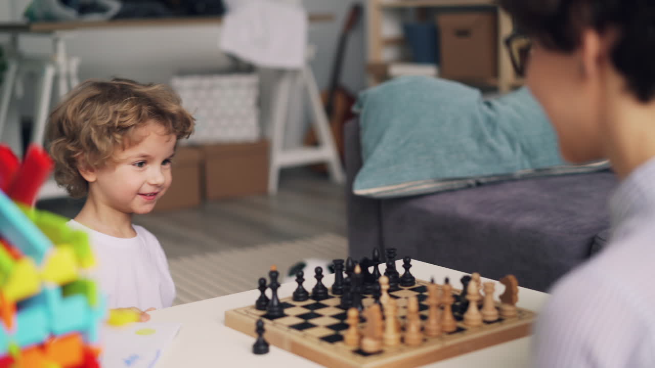 Child playing chess with parent