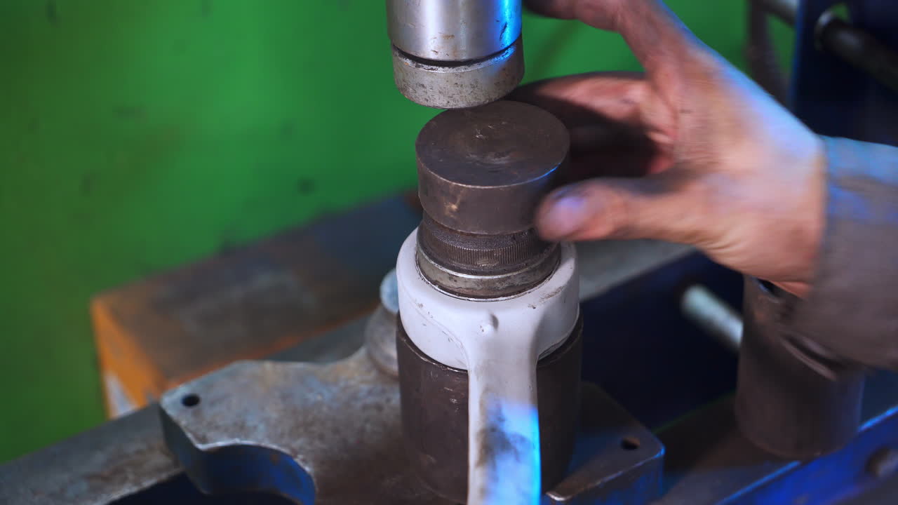 Turner's hand putting different details in a pile. Metal details stacked together. Equipment for turner close up. Blurred background.