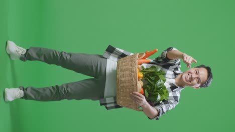 hombre sosteniendo una canasta de verduras