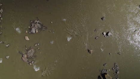 Vista-Aérea-De-Arriba-Hacia-Abajo-Del-Agua-Del-Lago-Glaciar-Pasterze-Muerto-Que-Fluye-Con-Trozos-De-Hielo,-Corriente-De-Agua-Fangosa-Del-Glaciar