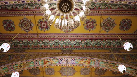 El-Diseño-Artístico-Del-Techo-Del-Templo-Con-Una-Lámpara-De-Araña-Encendida-Desde-Un-ángulo-Bajo-Se-Tomó-En-El-Templo-Jain-Soni-Ji-Ki-Nasiya,-Ajmer,-Rajasthan,-India,-El-19-De-Agosto-De-2023.