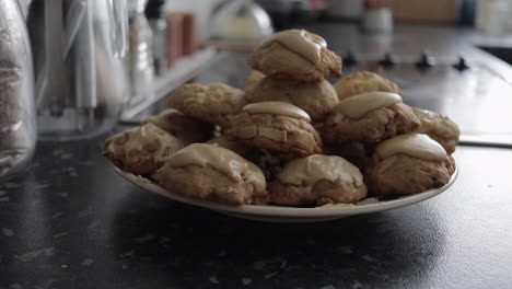 Slow-pan-left-to-right-of-plate-of-stacked-glazed-chocolate-and-almond-cookies