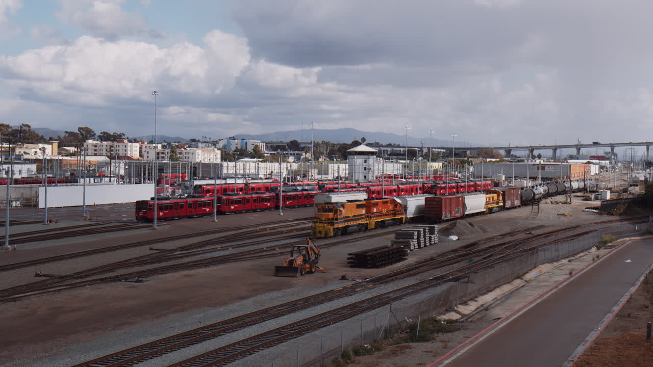 Rangierbahnhof in San Diego, Kalifornien mit der Coronado Bridge im Hintergrund an einem sonnigen Tag.
