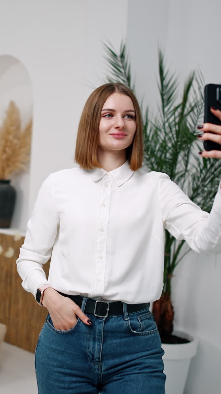 Modern Caucasian girl taking selfie in a light comfortable room