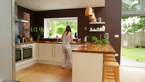 woman in pajamas in a modern kitchen