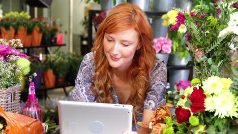 female florist using digital tablet in florist shop