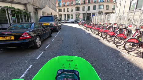 cyclist navigating busy london street with parked cars