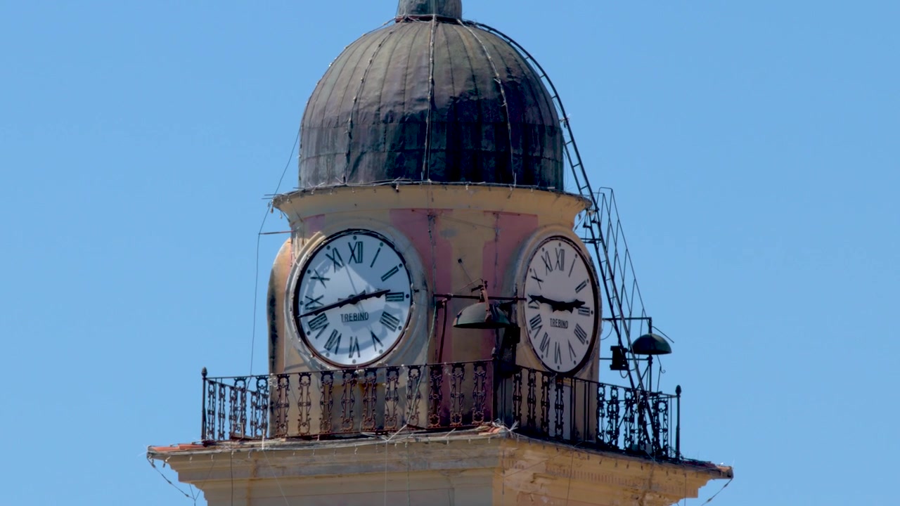 Static close up shot of a historic bell tower against a clear blue sky.