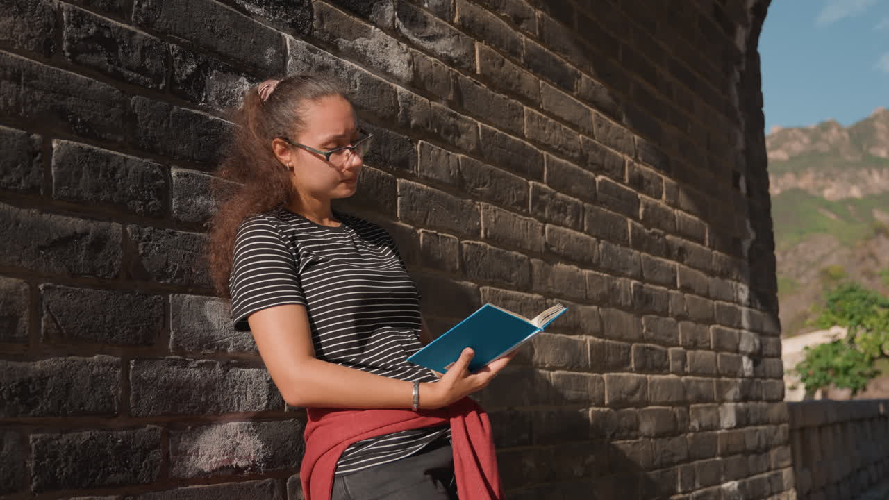 Sunlit archway writer reading journal by stone wall, warm golden light, historic courtyard steps in background, jotting notes and smiling, creative focus, intimate lifestyle portrait