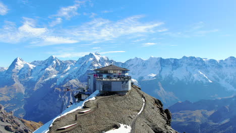 volando schilthorn piz gloria: fantástica toma sobre la estación y con vistas a espectaculares montañas cubiertas de nieve y en un paisaje suizo de otoño