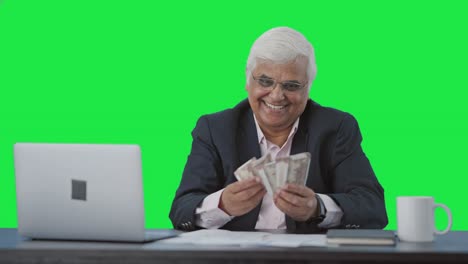 Happy-Indian-senior-businessman-counting-money-Green-screen