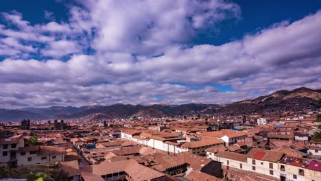 wide timelapse of cusco’s city main square and cathedral with clouds and mountain backdrop