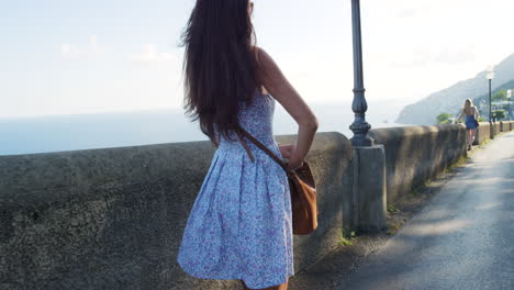 woman walking along the coastal road