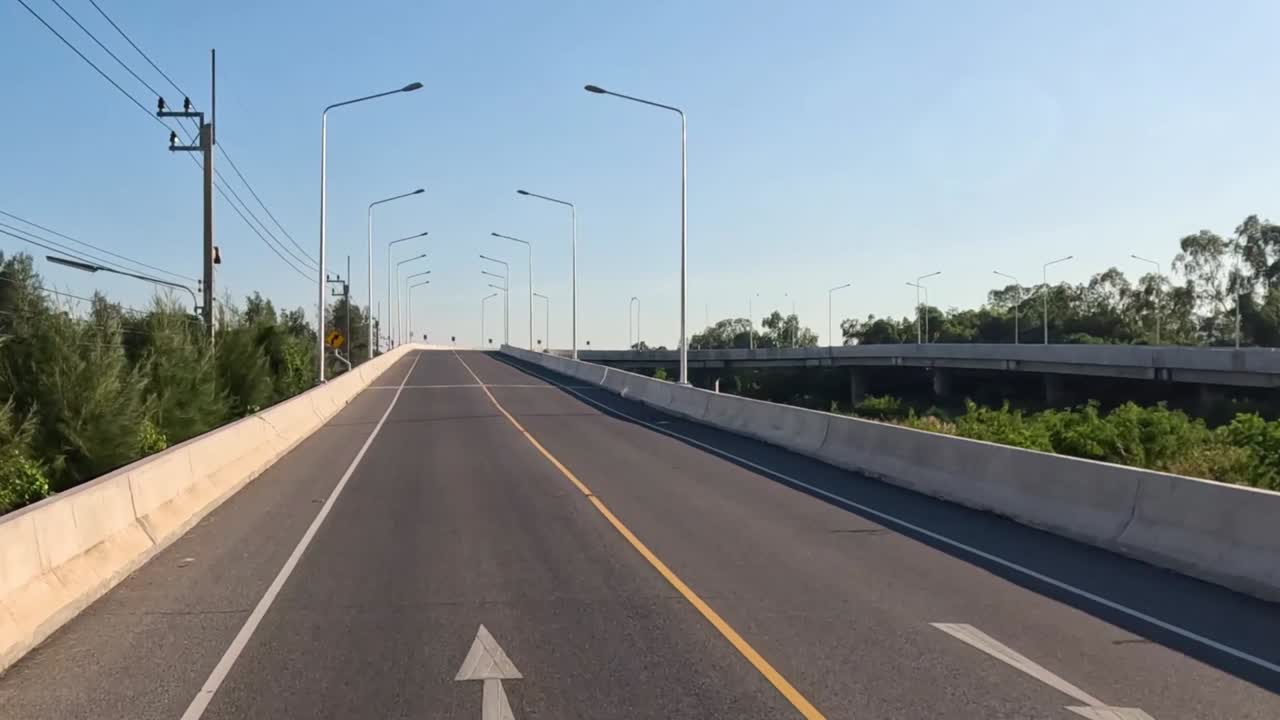 A journey along a winding road with clear skies and lush greenery, featuring mountain vistas.