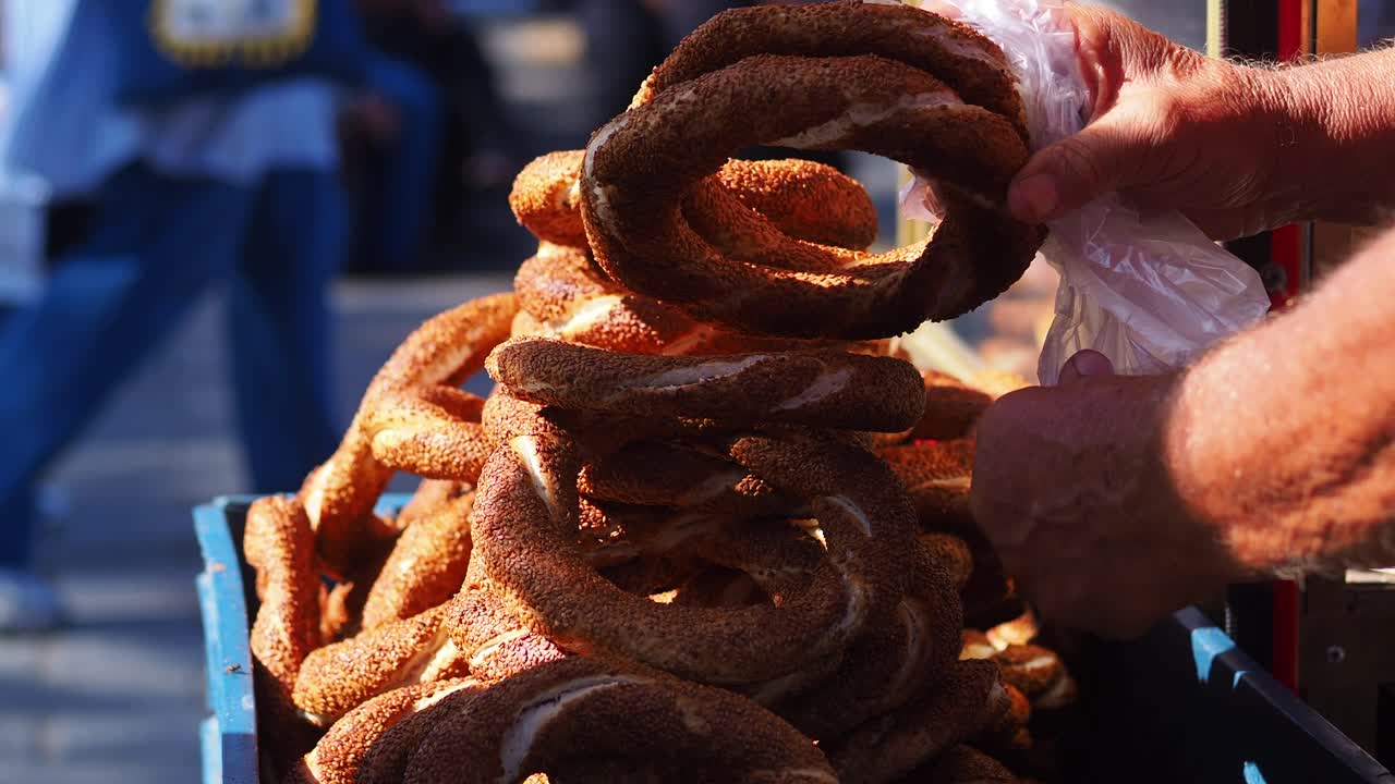 Close-Up of Hands Selling Traditional Turkish Simit Street Food