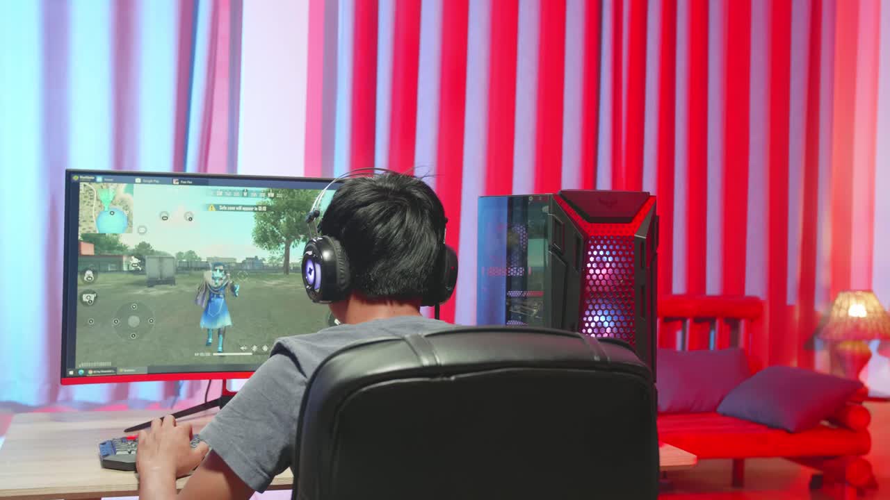 Asian Gamer Man Playing Survival Shooter Games On Computer