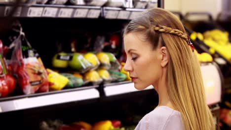 young smiling woman looking at vegetables