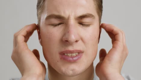 man covering ears in discomfort