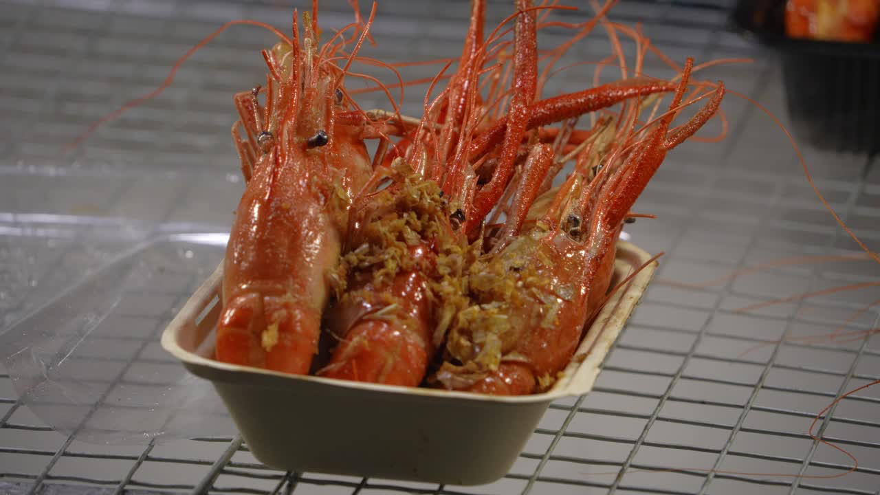 Gamberi all’aglio cotti in un contenitore di portata con vapore di ghiaccio secco che si solleva, creando una presentazione scenografica di street food