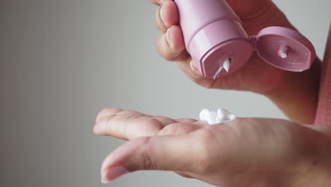 woman applying hand cream to her hand