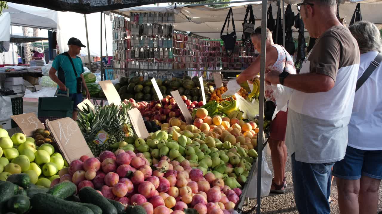 At the open-space market, people eagerly pick and select fresh fruits and vegetables, exploring vibrant stalls filled with seasonal produce and enjoying the lively atmosphere.