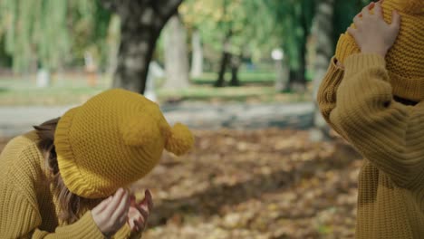 twins wearing the hats together at the park during the autumn.